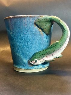 a ceramic mug with a fish sticking out of it