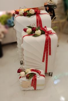 two white suitcases with red bows and flowers on them are sitting side by side