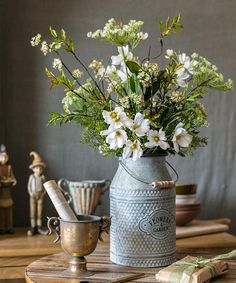 a vase filled with white flowers sitting on top of a table next to other items