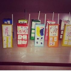 there are many different colored toothbrushes lined up on the counter top, and one is painted with children's drawings