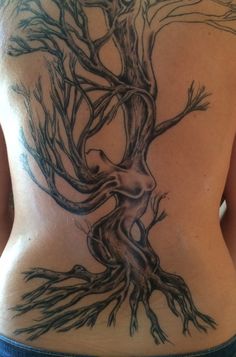 a woman's back with a tree tattoo on her lower back and bottom part