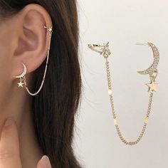 a woman wearing two different ear chains with stars and moon charms on each side of her ear