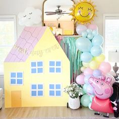 a birthday party with balloons and decorations in the shape of a house, peppa pig