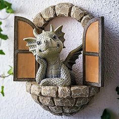 a statue of a dragon sitting on top of a window sill