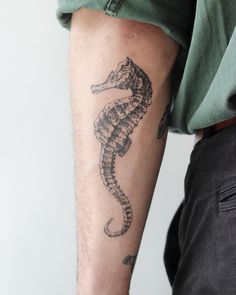 a man with a seahorse tattoo on his arm