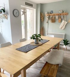 a wooden table sitting in the middle of a room next to a white radiator