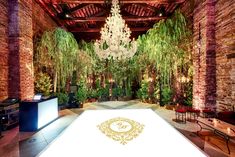 a large room with a chandelier hanging from the ceiling and plants on the walls