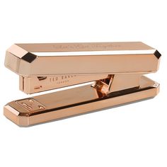 a gold stapler sitting on top of a white surface