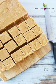 cut up pieces of peanut butter fudge on a cutting board with a knife next to it