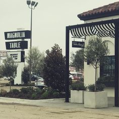 an empty parking lot in front of a restaurant with black and white awnings