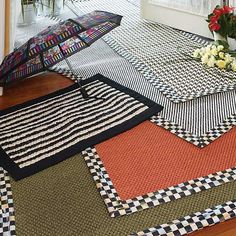 an open umbrella sitting on top of a rug next to flowers and potted plants