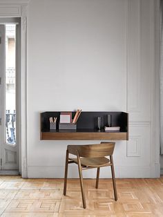 a wooden chair sitting in front of a desk on top of a hard wood floor