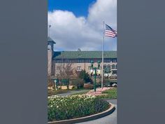 an american flag flying in front of a large building