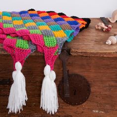 a multicolored blanket sitting on top of a wooden table