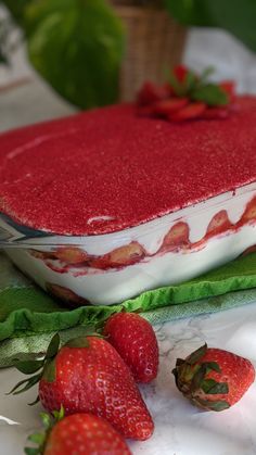 two strawberries sit next to a cake on a table