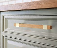 a close up of a drawer with some wood handles on the top and bottom drawers