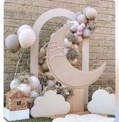 a baby's first birthday decoration with balloons and decorations on the outside wall, in front of a brick building