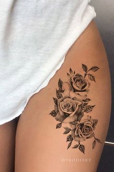 a woman's thigh with tattoos on it and roses in the middle of her thighs