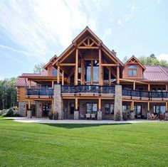 a large wooden house sitting on top of a lush green field