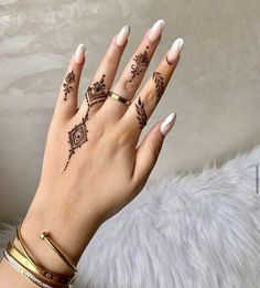 a woman's hand with hennap tattoos on her left wrist and fingers