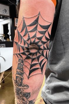 a man with a spider web tattoo on his arm