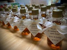 small bottles filled with honey sitting on top of a wooden table next to each other