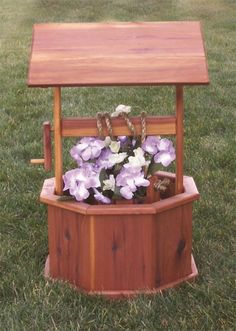 a wooden bench with flowers in it on the grass