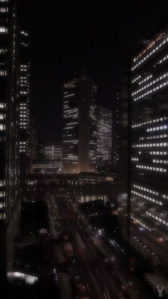 cityscape at night with cars and buildings in the foreground