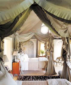 a canopy bed in a bedroom next to a dresser