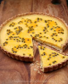 a quiche on a wooden cutting board with one slice cut out and the other half eaten