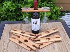 several wine bottles are sitting on a table next to some wooden utensils with holes in them