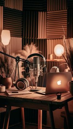 an apple computer sitting on top of a wooden table next to a microphone and headphones