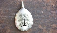 a silver spoon with a tree on it