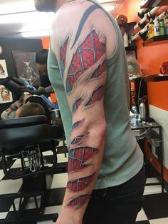 a man with a tattoo on his arm in a barbershop looking at the mirror