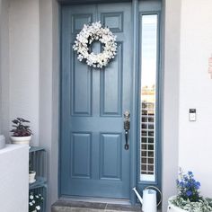 a blue front door with a wreath on it