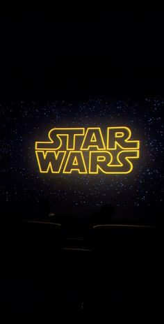 the star wars logo is lit up in the dark