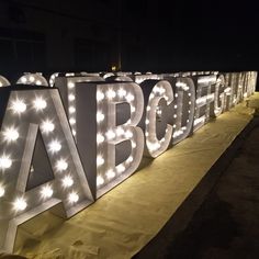 the letters are lit up and ready to be used for an outdoor party or event