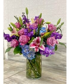 a vase filled with purple and blue flowers