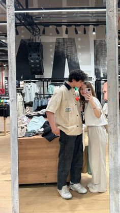 a man and woman standing in front of a clothing store