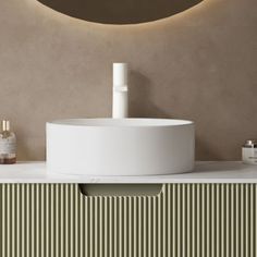 a white sink sitting on top of a counter next to a wall mounted faucet