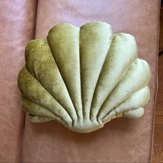 a scallop shell shaped pillow sitting on top of a couch