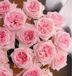 a bouquet of pink roses sitting on top of a table