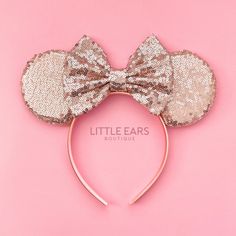 a gold minnie mouse ears headband with sequins on it and a bow at the top