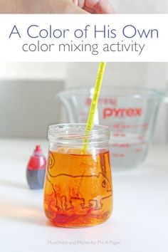 a child's hand holding a yellow straw in a jar filled with orange liquid