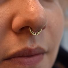 a close up of a person with a nose ring on their left side, wearing an earring