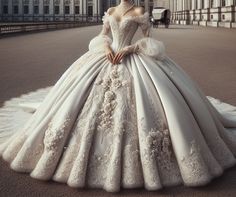 a woman in a white wedding dress standing on the street with her hands behind her back