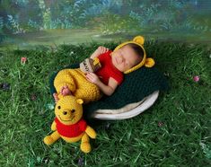 a baby sleeping on top of a pillow next to a winnie the pooh stuffed animal