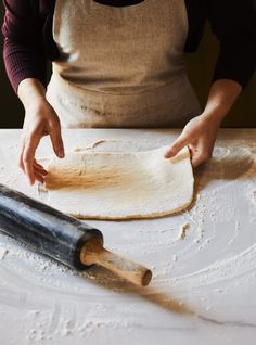 a person making dough with a rolling pin