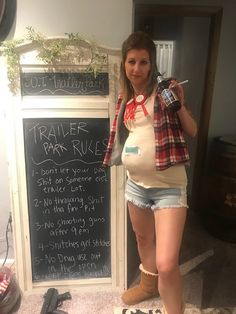 a pregnant woman standing in front of a chalkboard