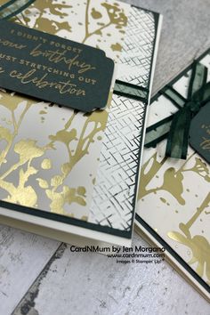 two cards with gold and black foil on them, one has a tag that says happy birthday